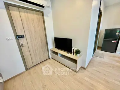 Modern apartment interior with wooden flooring, TV stand, and air conditioning unit.