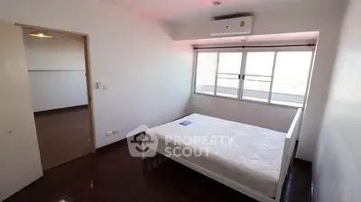Spacious bedroom with large window and air conditioning in modern apartment