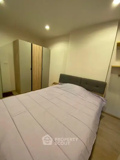 Cozy bedroom with modern wardrobe and stylish bed in a well-lit apartment.