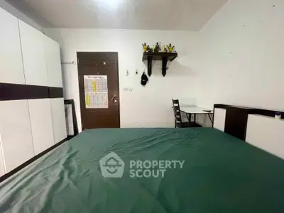 Cozy bedroom with green bedspread and modern furniture