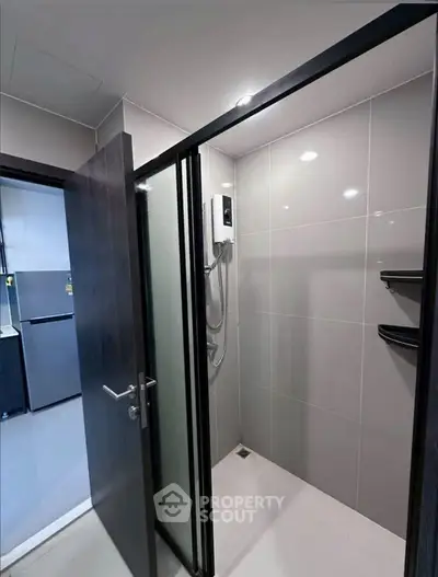 Modern bathroom with sleek shower and glass door in contemporary apartment.