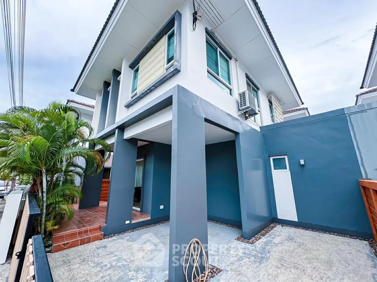 Modern two-story house with sleek design and spacious driveway, perfect for contemporary living.