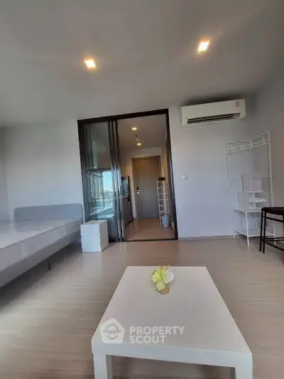 Modern minimalist living room with air conditioning and sleek furniture in a bright apartment.