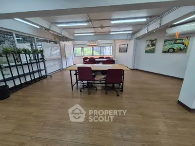 Spacious office space with modern furnishings and large windows for natural light.