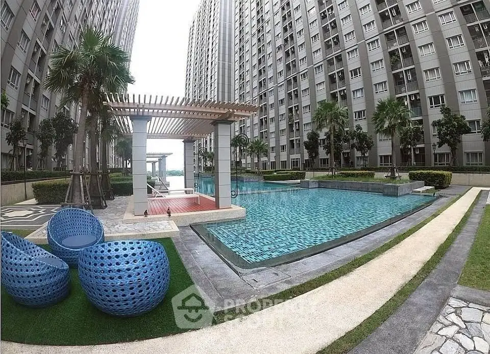 Luxurious apartment complex with stunning pool and modern outdoor seating area.