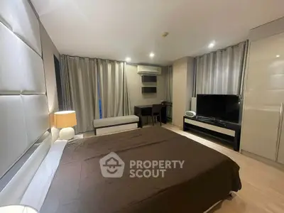 Spacious modern bedroom with elegant decor and large TV unit
