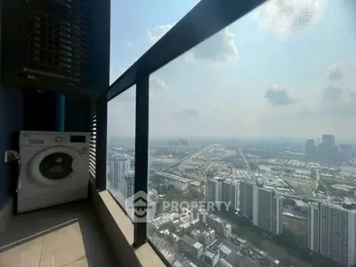 Stunning high-rise balcony with panoramic city view and washing machine setup.
