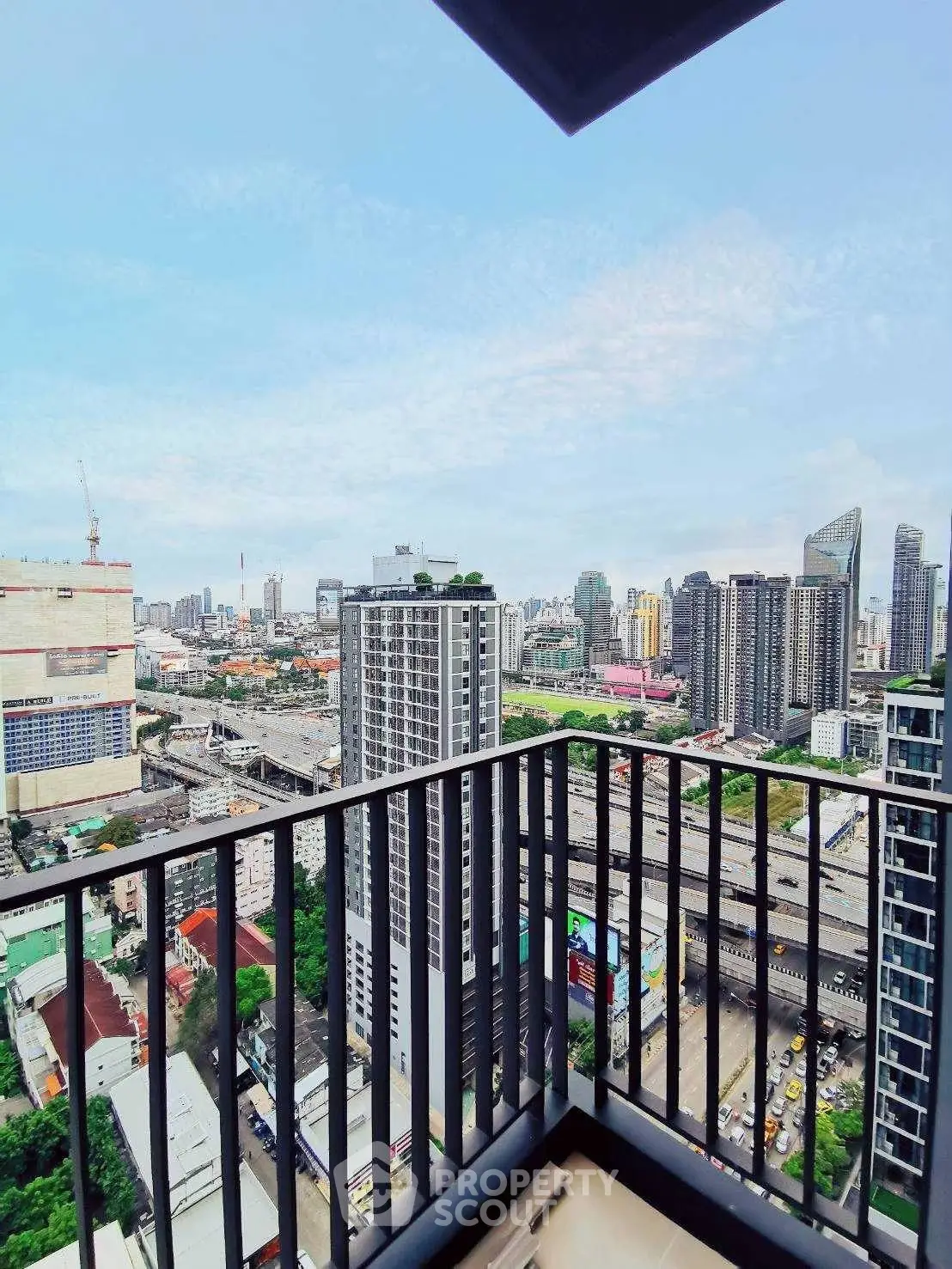 Stunning cityscape view from a high-rise balcony, showcasing urban skyline and vibrant city life.