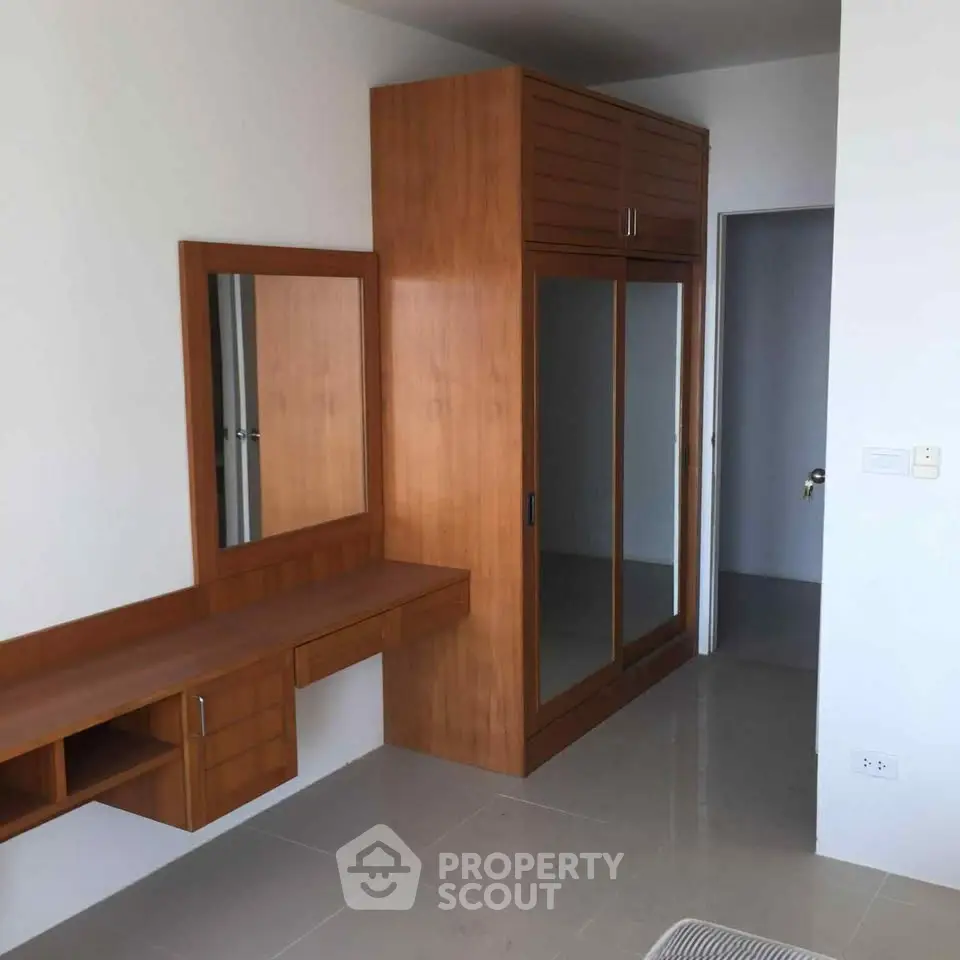 Modern bedroom with built-in wooden wardrobe and vanity in a minimalist design.