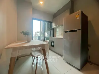 Modern kitchen with sleek appliances and dining area in a cozy apartment setting.