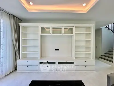 Spacious modern living room with built-in white shelving and elegant lighting