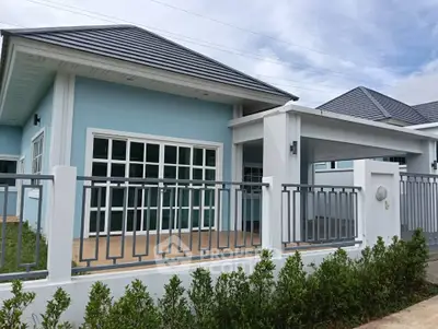 Modern blue single-story house with spacious front patio and stylish fence.