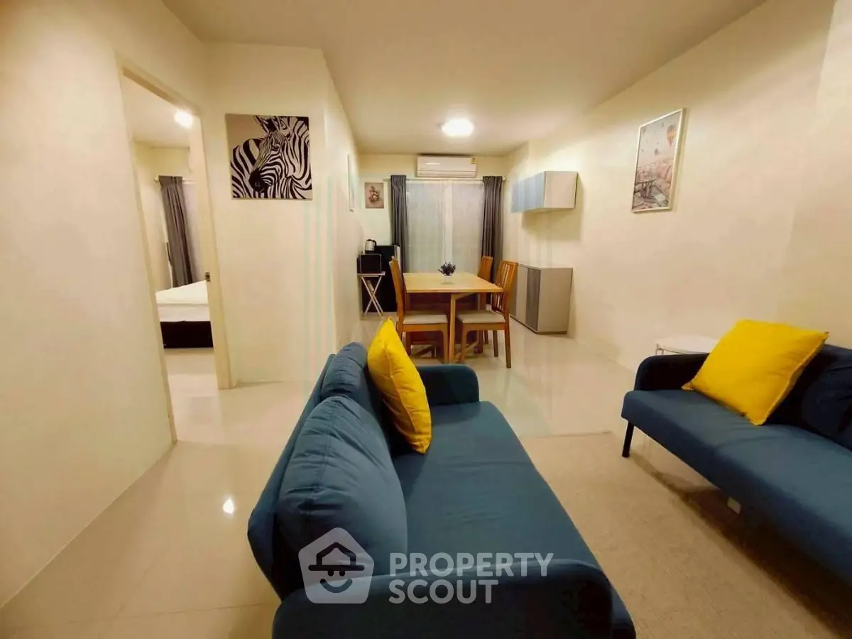 Spacious living room with modern decor and vibrant accents in a cozy apartment.