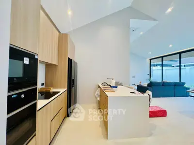 Modern open-layout kitchen with sleek appliances and spacious living area in a stylish home.