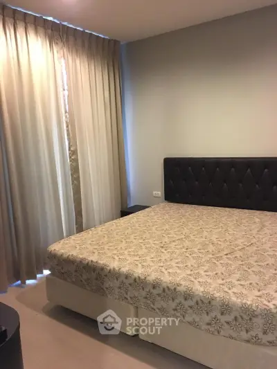 Cozy bedroom with elegant curtains and stylish headboard in modern apartment.