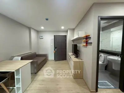 Modern living room with sleek furniture and open layout, adjacent to a stylish bathroom.