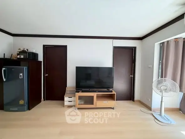 Spacious living room with modern TV setup and sleek wooden flooring