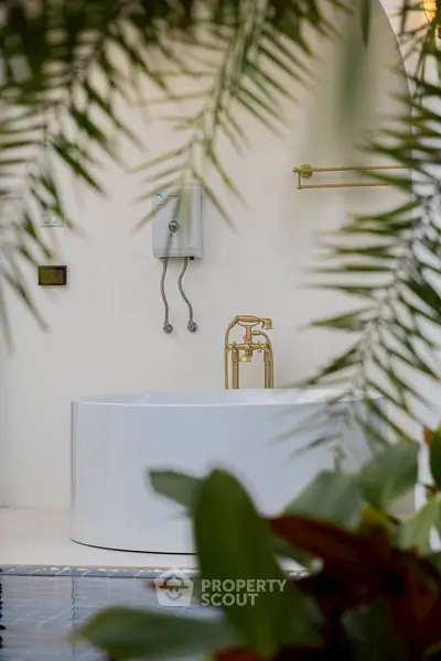 Luxurious bathroom with elegant bathtub and tropical decor