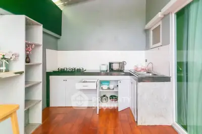 Charming kitchen with open layout and modern appliances, featuring sleek countertops and wooden flooring.