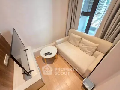Cozy living room with modern TV setup and comfortable sofa in a bright apartment.