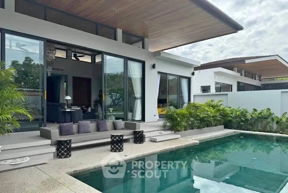 Luxurious modern villa with private pool and elegant outdoor seating area.
