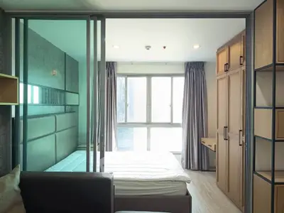 Modern bedroom with large window and stylish built-in wardrobe