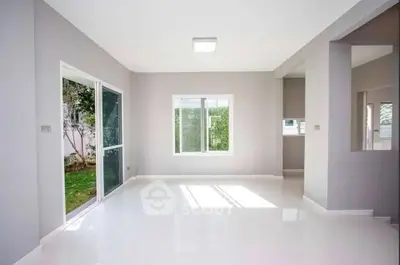 Spacious empty living room with large windows and garden view