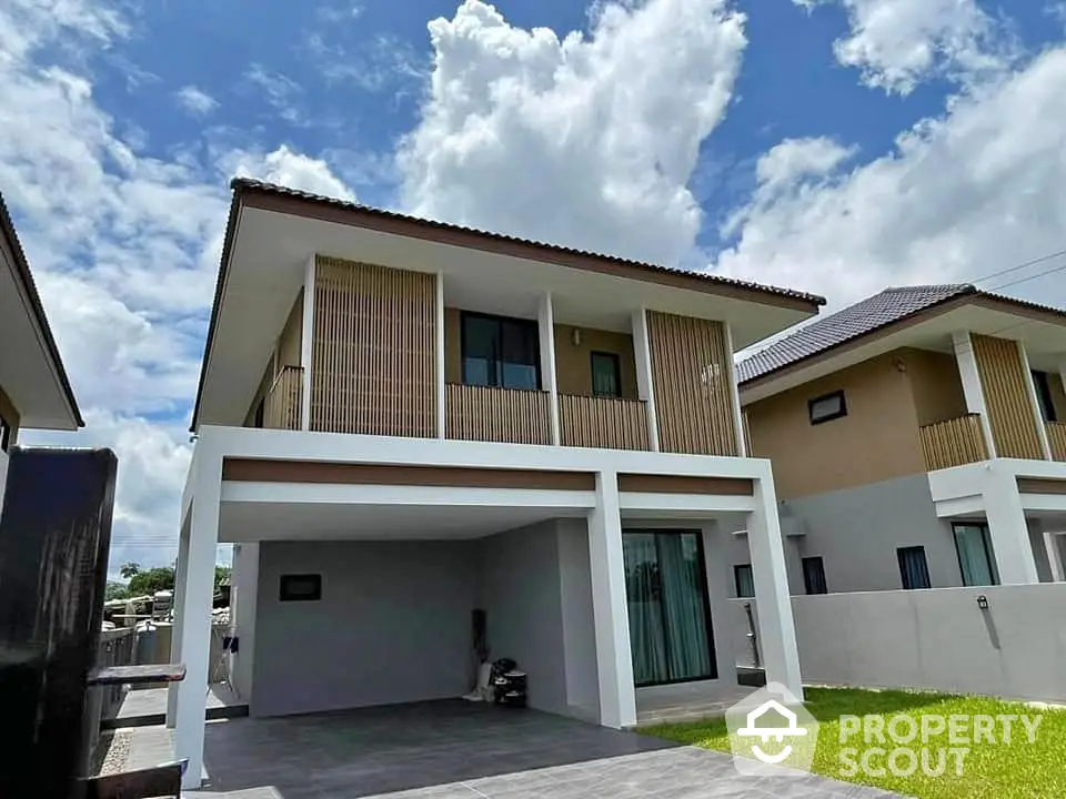 Modern two-story house with spacious driveway and lush green lawn under a clear blue sky.