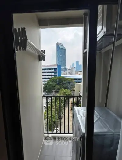 Compact balcony with city view and laundry area in modern apartment
