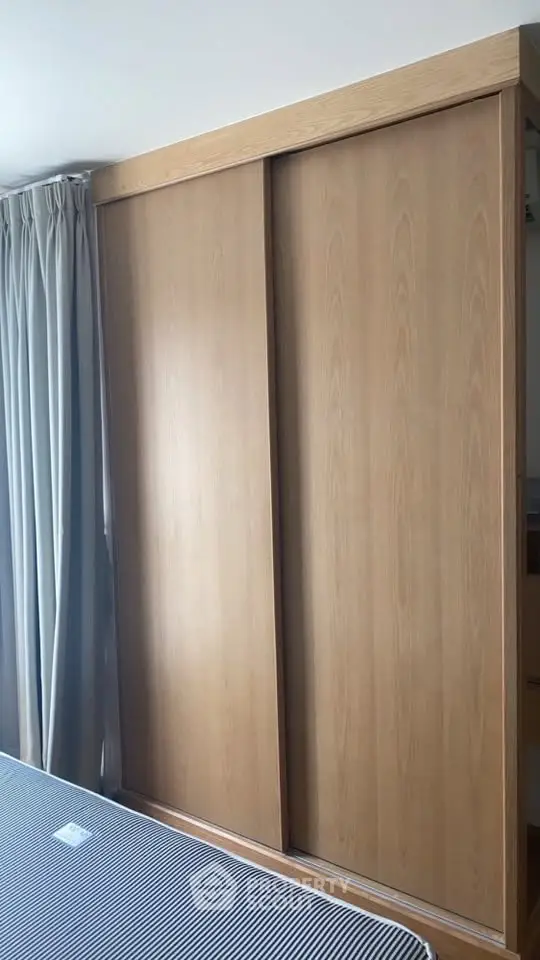 Spacious bedroom with modern wooden wardrobe and elegant curtains