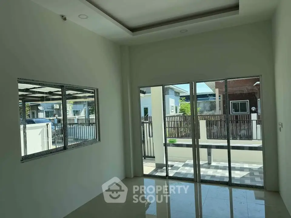 Bright room with large windows and sliding doors opening to a patio, perfect for natural light.