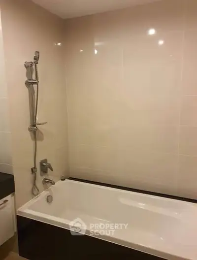 Modern bathroom with sleek bathtub and shower in contemporary design.