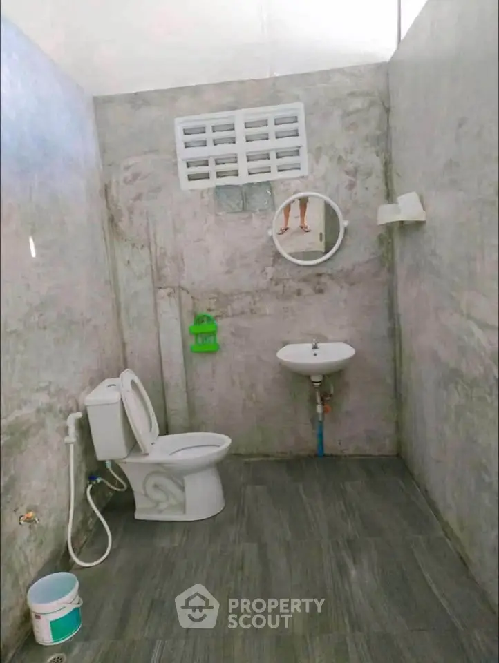 Minimalist bathroom with concrete walls and basic fixtures