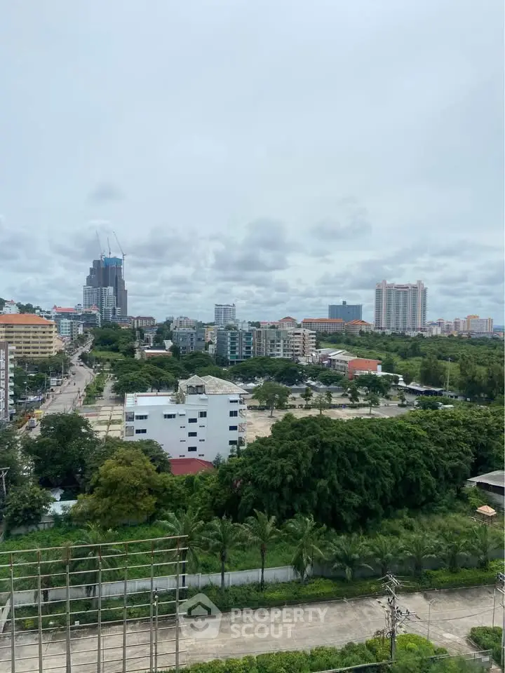Stunning cityscape view from a high-rise building showcasing lush greenery and urban skyline.