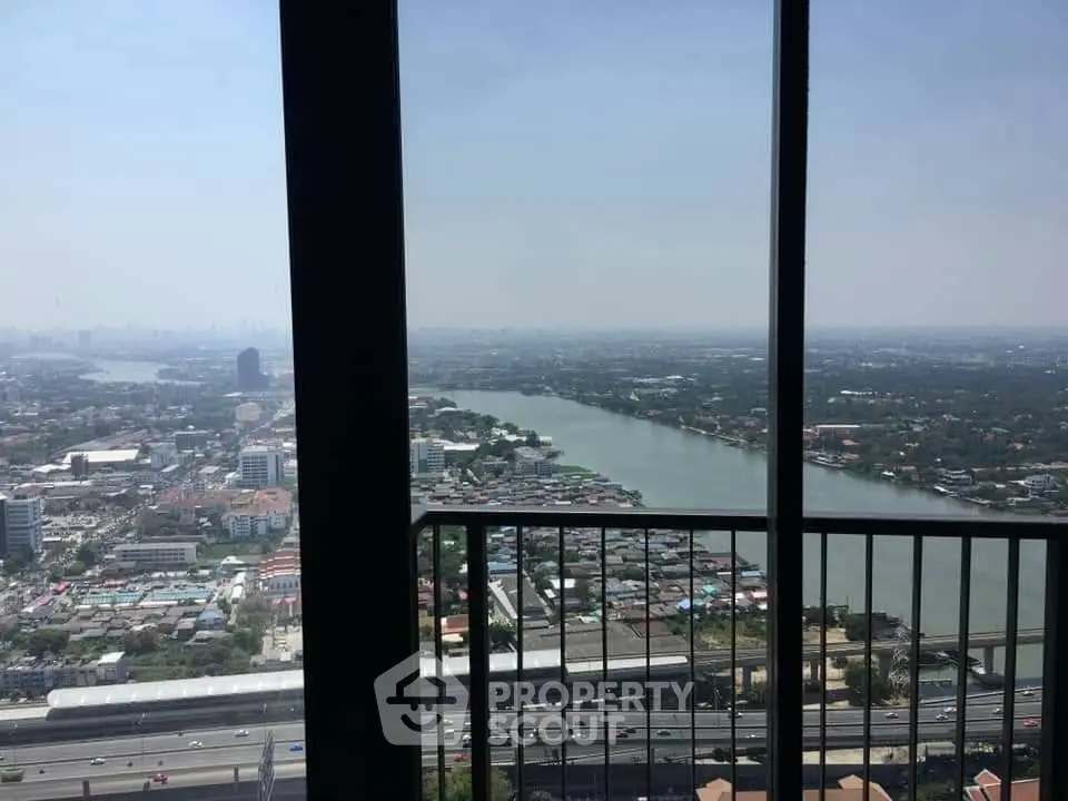Stunning high-rise view of cityscape and river from a balcony, perfect for urban living.