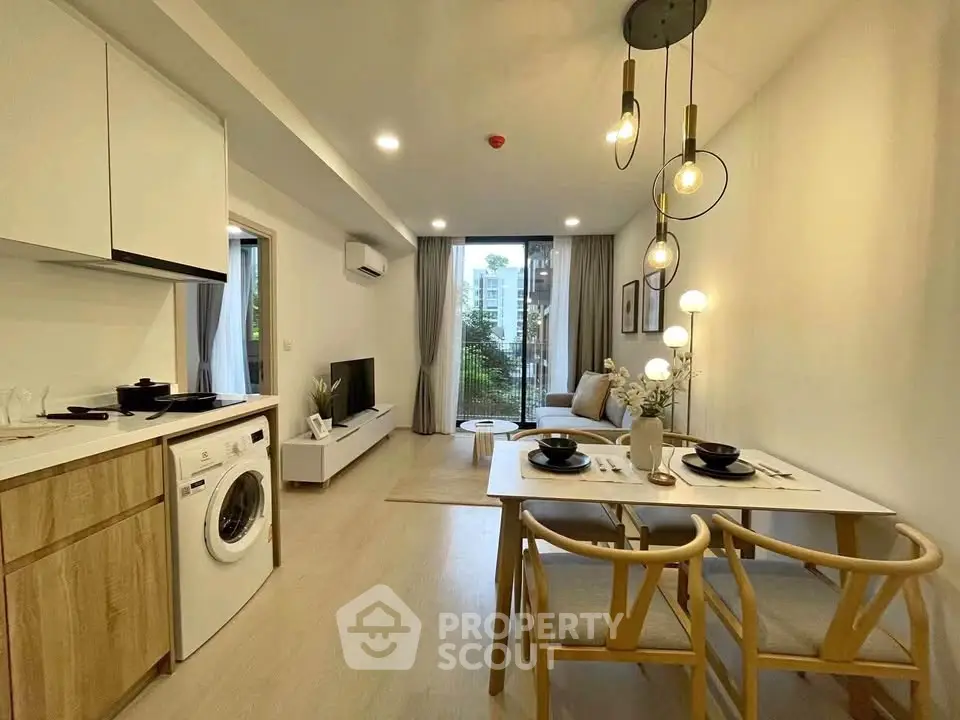 Modern open-plan living room with kitchen, featuring stylish furniture and natural light.