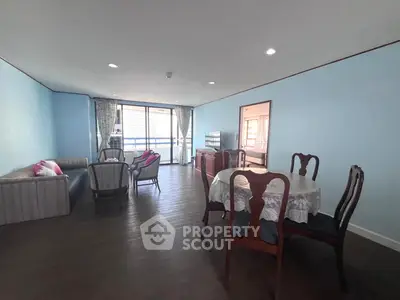 Spacious living room with elegant dining area and balcony access in modern apartment.