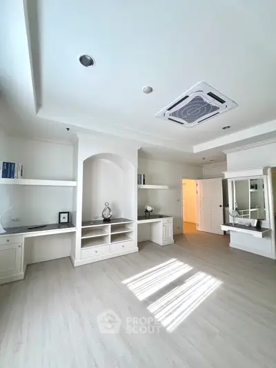 Spacious modern living room with built-in shelves and elegant ceiling design