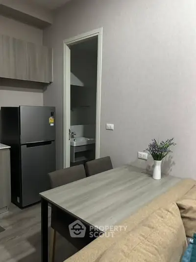 Modern kitchen with dining area and sleek appliances in a cozy apartment.