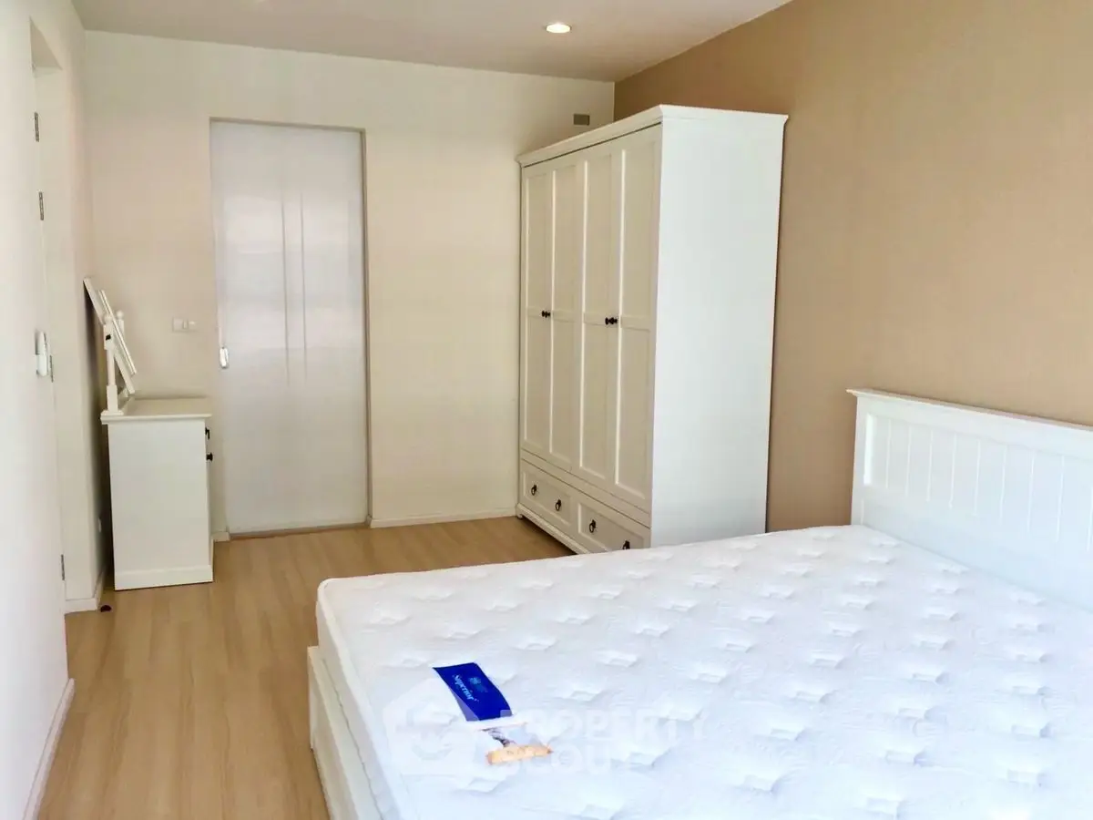 Spacious bedroom with white furniture and natural light