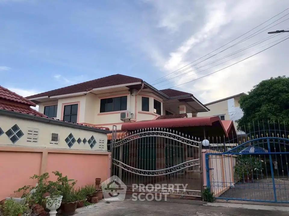 Charming two-story house with gated entrance and spacious driveway in a serene neighborhood.
