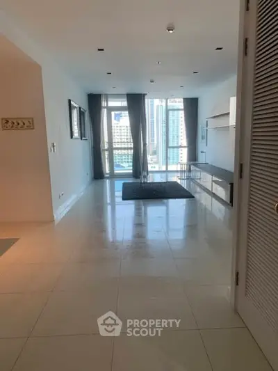 Spacious modern living room with city view and sleek tile flooring.