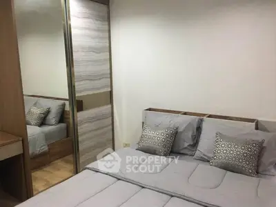 Modern bedroom with stylish decor and mirrored wardrobe in a cozy apartment.