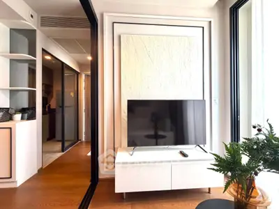 Modern living room with sleek TV setup and stylish decor in a contemporary apartment.