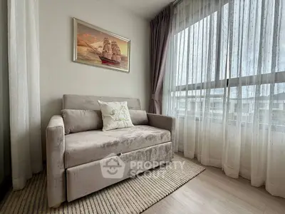 Cozy living room with plush sofa and large window offering natural light