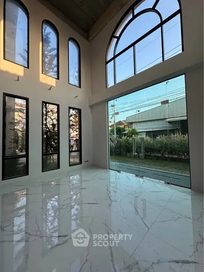 Spacious modern living room with high ceilings and large windows offering abundant natural light.