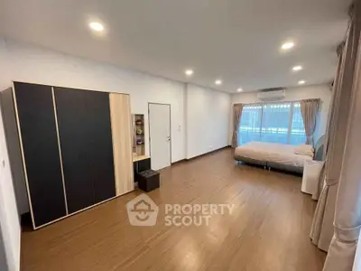 Spacious bedroom with modern design, featuring large windows and ample natural light.
