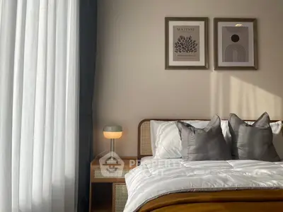 Cozy bedroom with stylish decor, featuring a comfortable bed, elegant lamp, and framed artwork on the wall.
