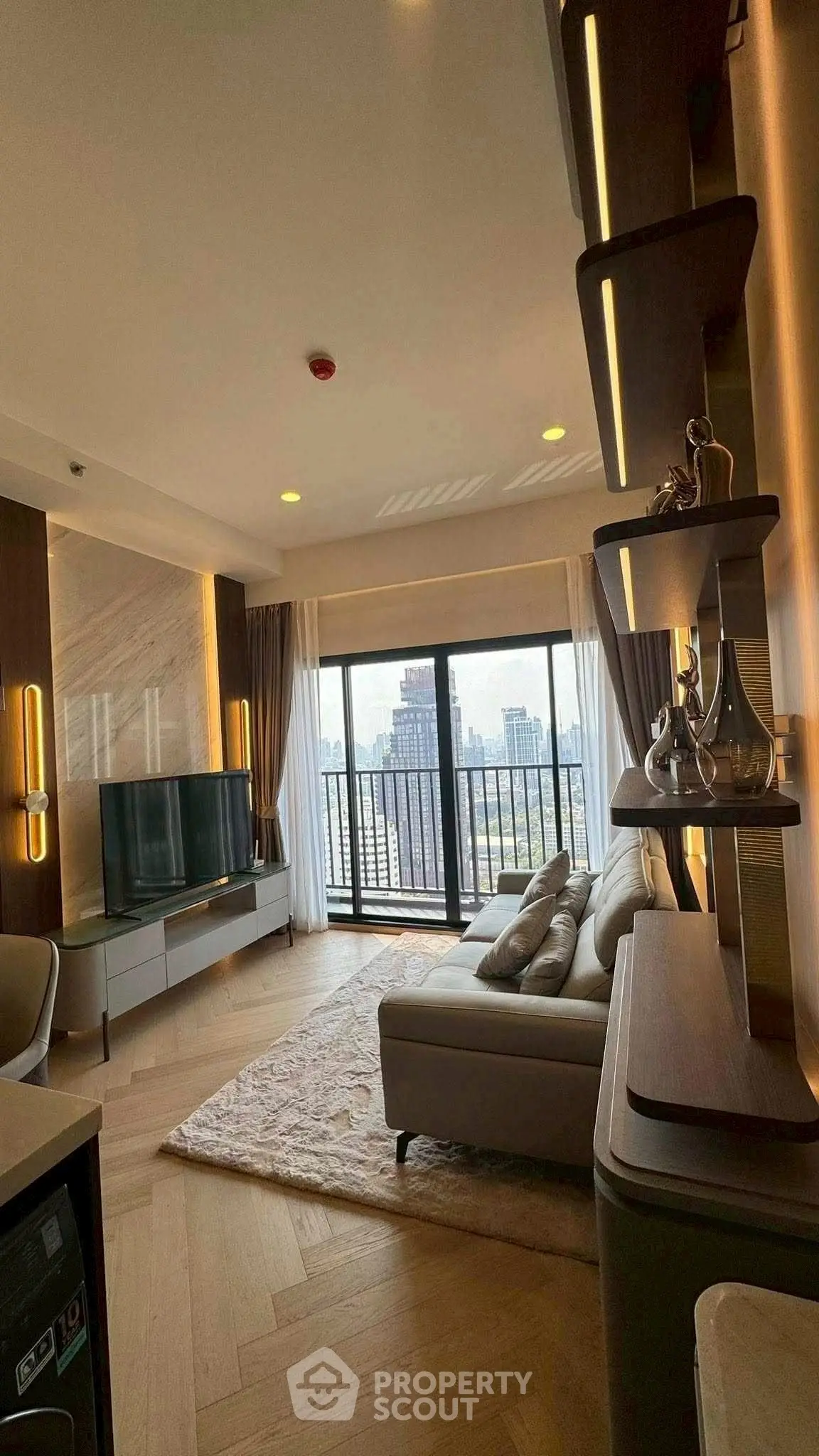 Luxurious living room with modern decor and stunning city view from balcony.