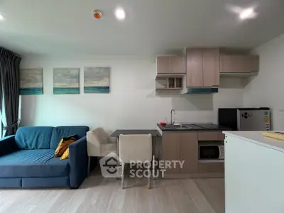 Modern studio apartment with cozy living area and compact kitchen, perfect for urban living.